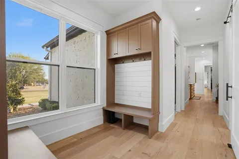 a view of a hallway with wooden floor and windows