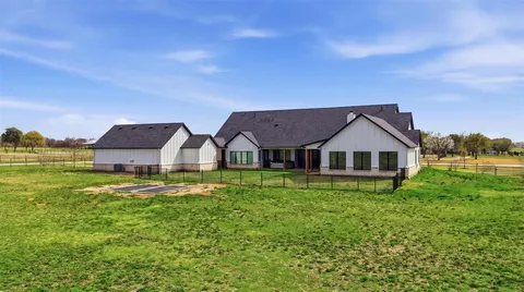 a view of a big house with a big yard and large tree