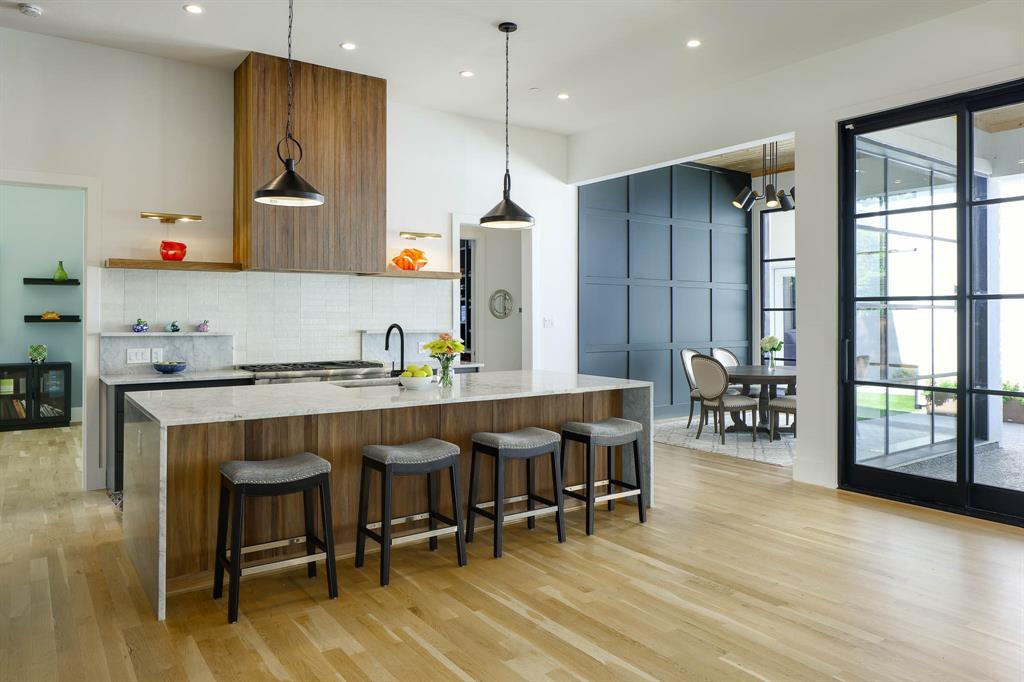 7149 Northaven Road Dallas, TX 75230 - Photo 8 of 25 a kitchen with stainless steel appliances granite countertop a table chairs sink and wooden floor
