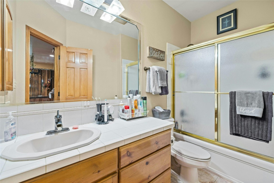 14410 Hero Way West Leander, TX 78641 - Photo 25 of 39 a bathroom with a sink a toilet and a large mirror