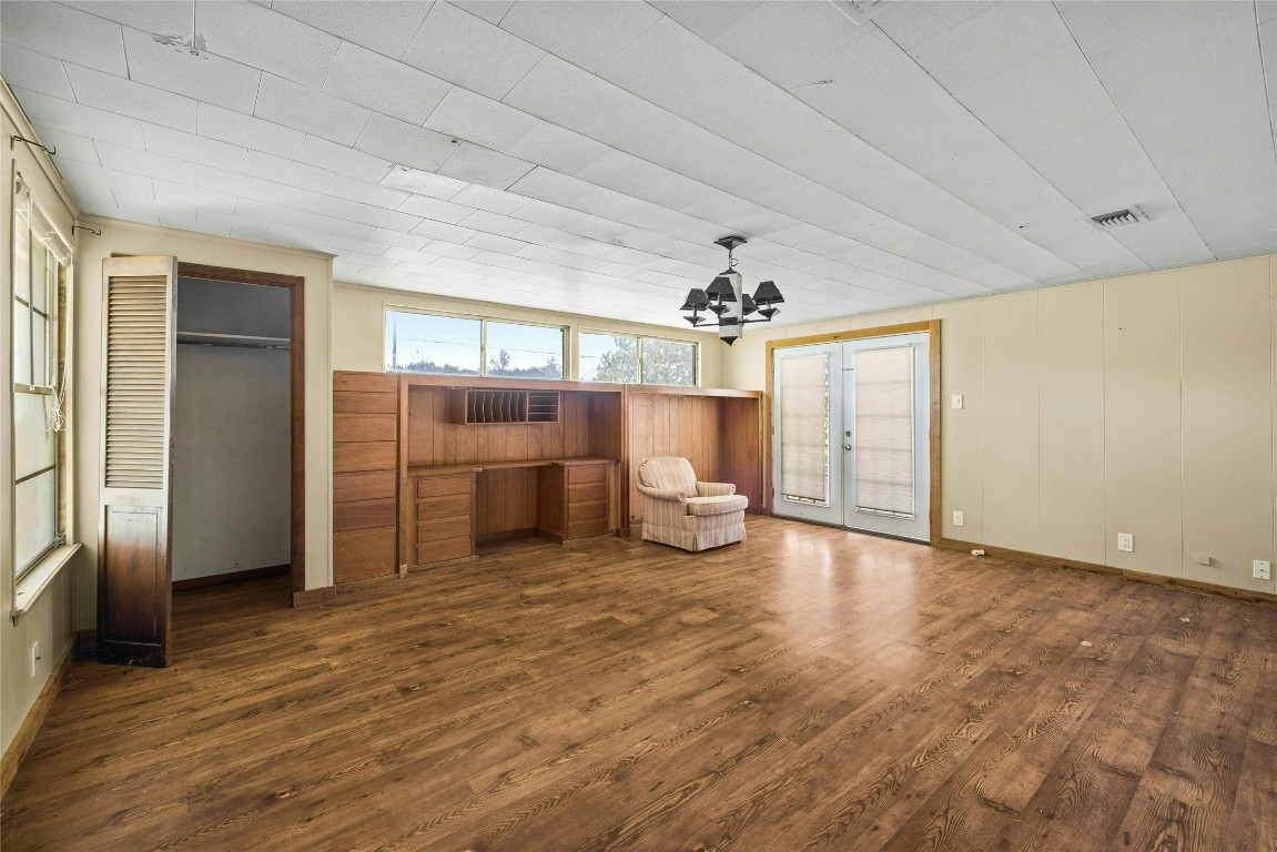 14410 Hero Way West Leander, TX 78641 - Photo 34 of 39 an empty room with wooden floor kitchen view and windows