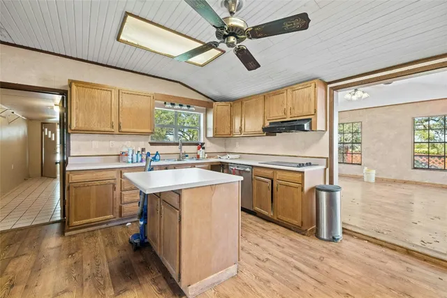 a kitchen with a refrigerator a sink and dishwasher with wooden floor