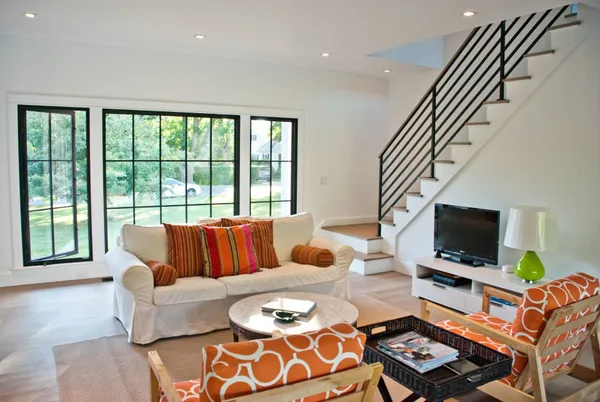 a living room with furniture a flat screen tv and a window