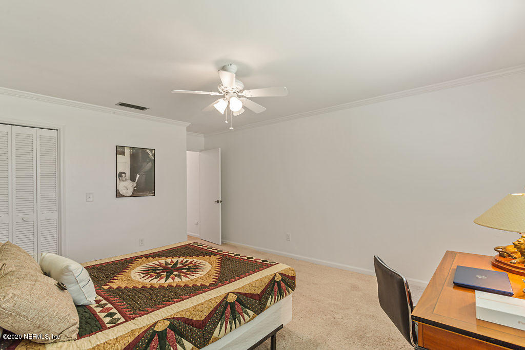 9625 Beauclerc Bluff Road Jacksonville, FL 32257 - Photo 20 of 30 a bedroom with a bed and a chandelier