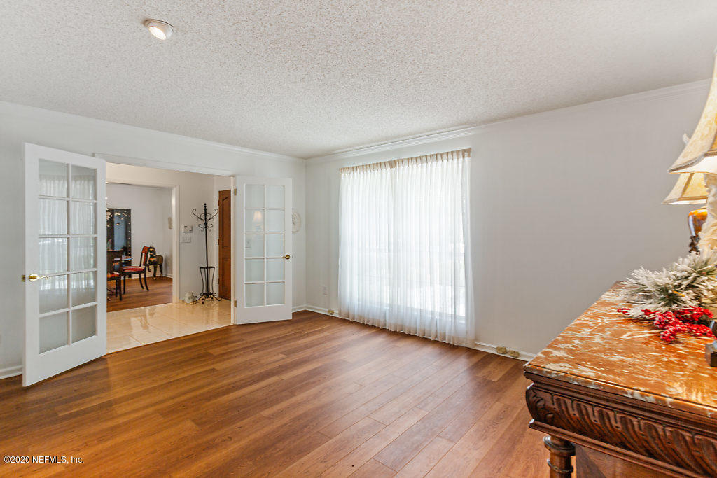 9625 Beauclerc Bluff Road Jacksonville, FL 32257 - Photo 6 of 30 an empty room with wooden floor and windows