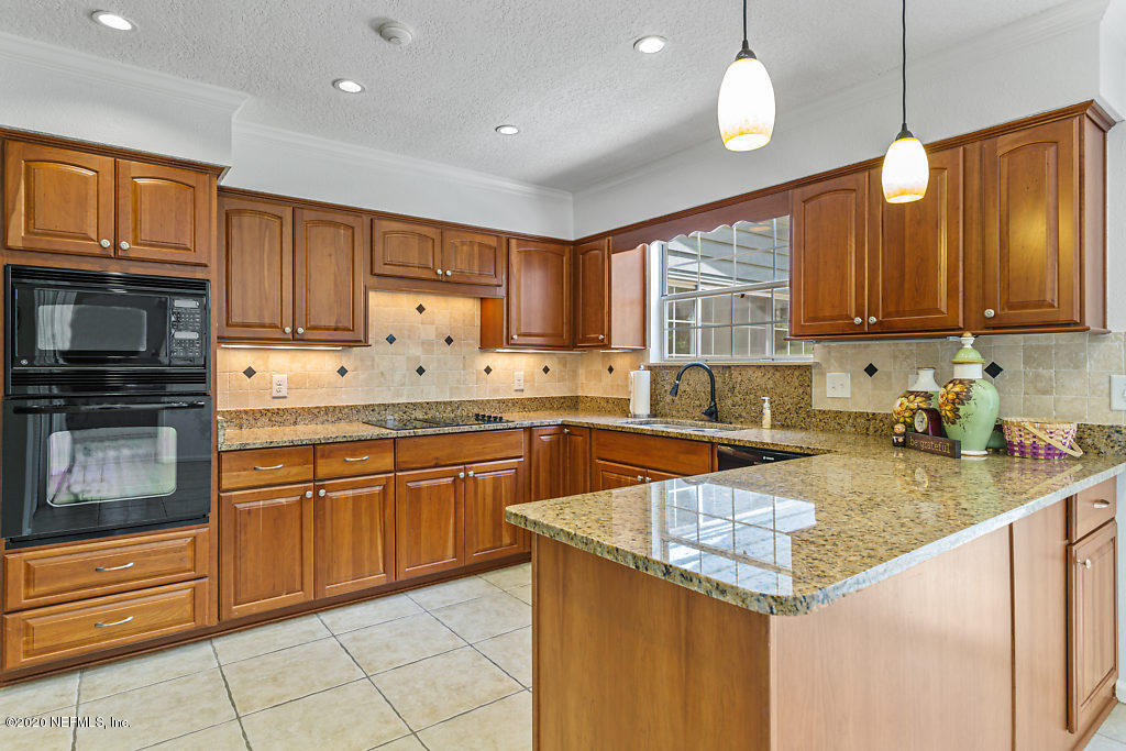 9625 Beauclerc Bluff Road Jacksonville, FL 32257 - Photo 10 of 30 a kitchen with granite countertop stainless steel appliances a stove sink microwave and cabinets
