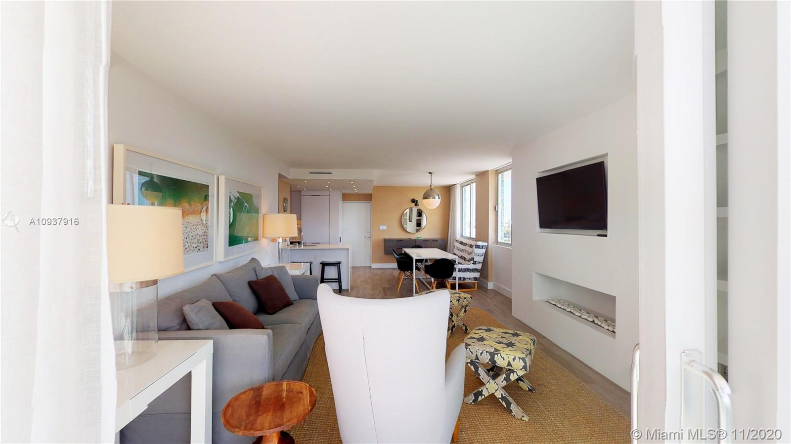 West Avenue Miami Beach, FL 33139 - Photo 12 of 29 a living room with furniture a flat screen tv and white walls