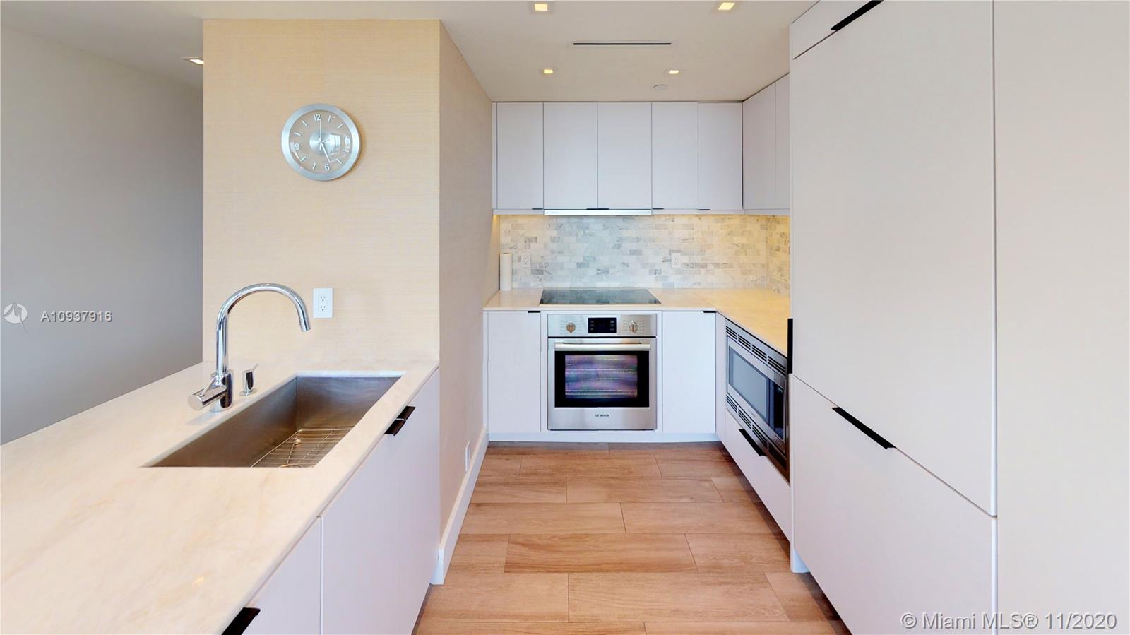 West Avenue Miami Beach, FL 33139 - Photo 9 of 29 a kitchen with stainless steel appliances granite countertop a sink and dishwasher a stove with wooden floor