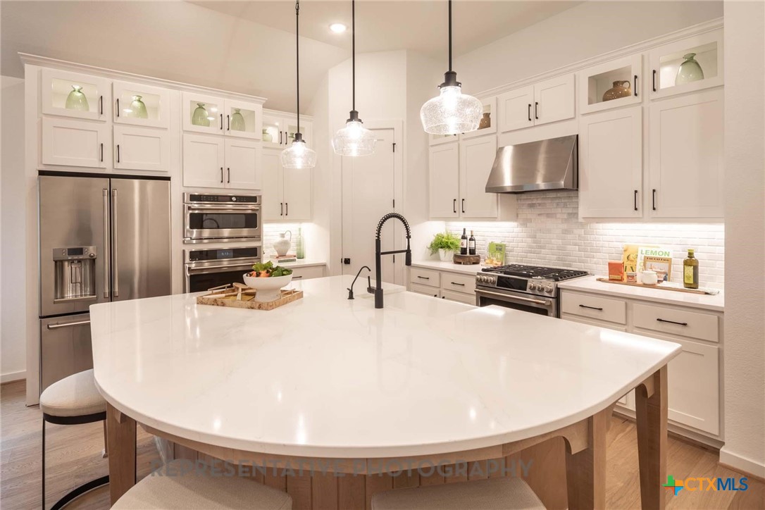 620 High Summit Drive Georgetown, TX 78628 - Photo 16 of 28 a kitchen with stainless steel appliances a stove a sink a microwave a refrigerator and cabinets