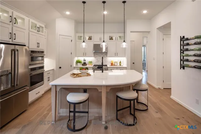 a kitchen with refrigerator and chairs