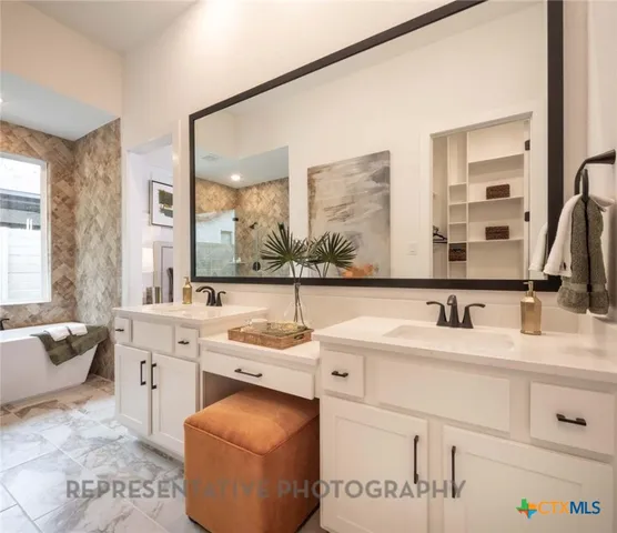 a bathroom with a double vanity sink mirror and bathtub