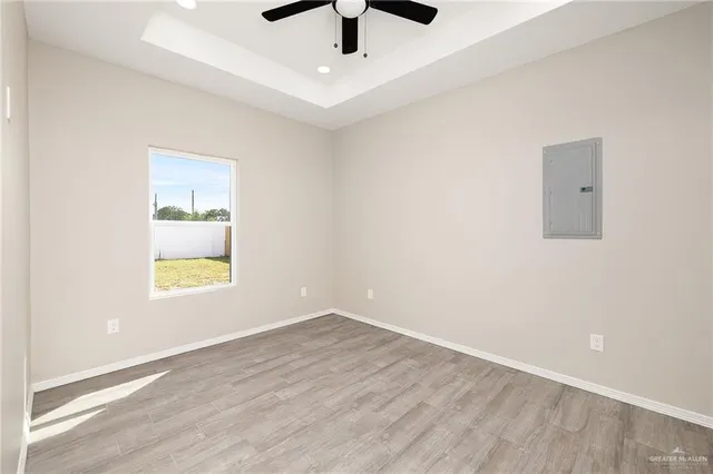 an empty room with a window and a ceiling fan