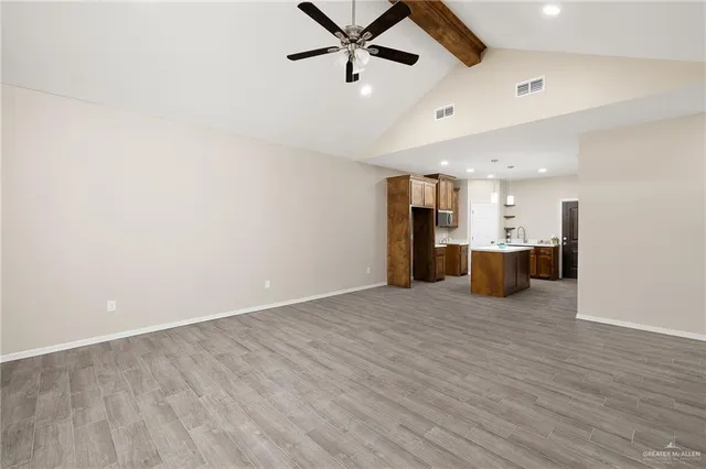 a view of empty room with wooden floor and a ceiling fan