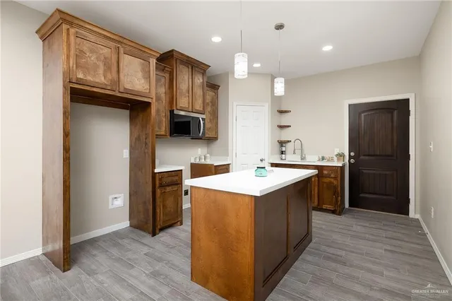 a kitchen with a sink refrigerator and a microwave
