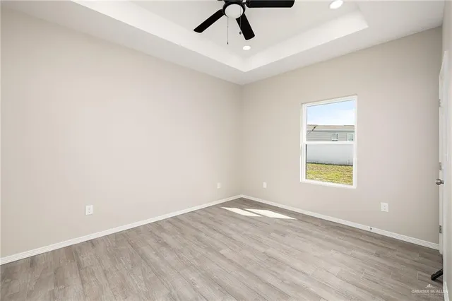 an empty room with a window and a ceiling fan