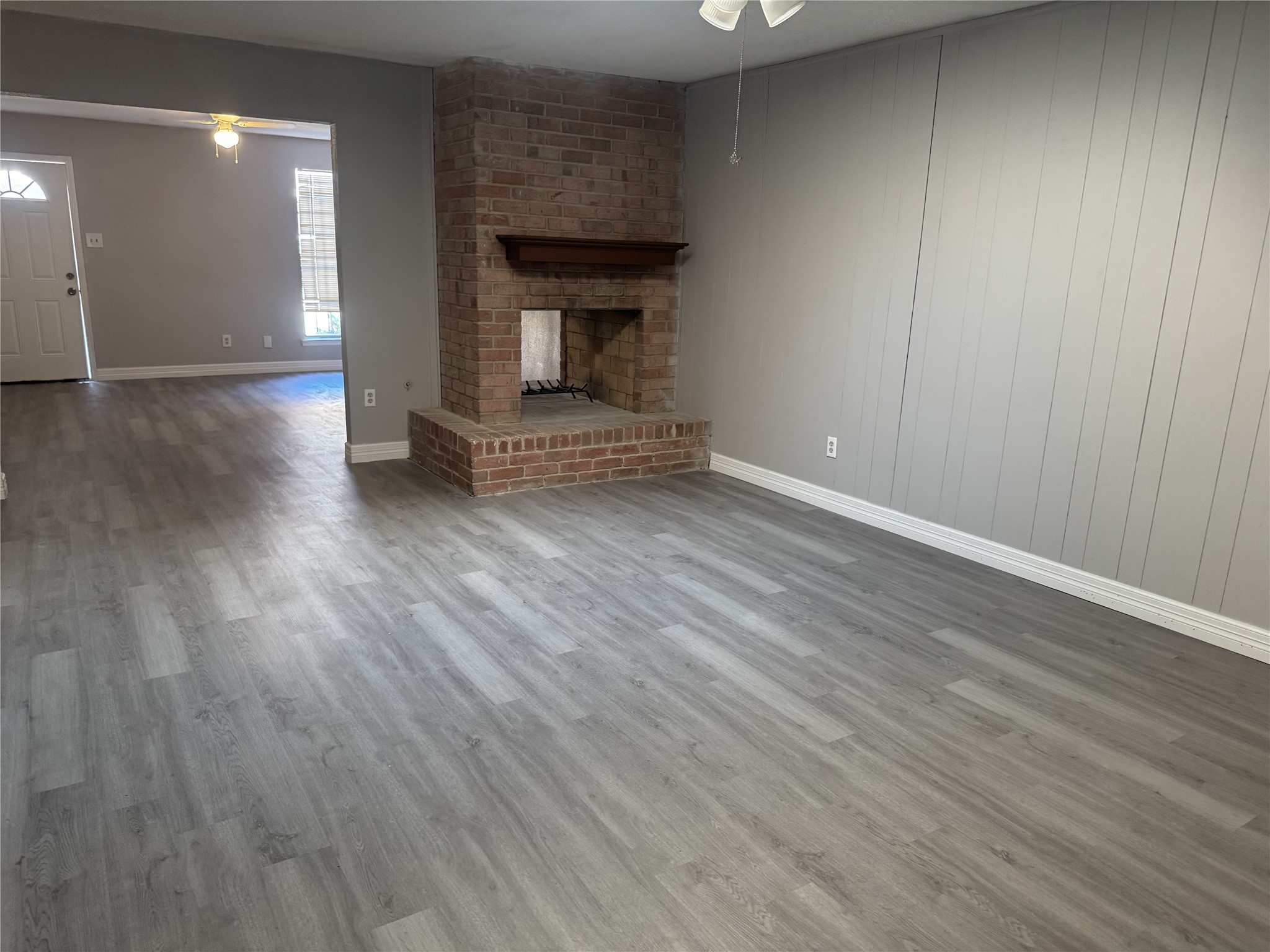 9537 Braeburn Glen Boulevard Houston, TX 77074 - Photo 11 of 15 an empty room with wooden floor fireplace and windows