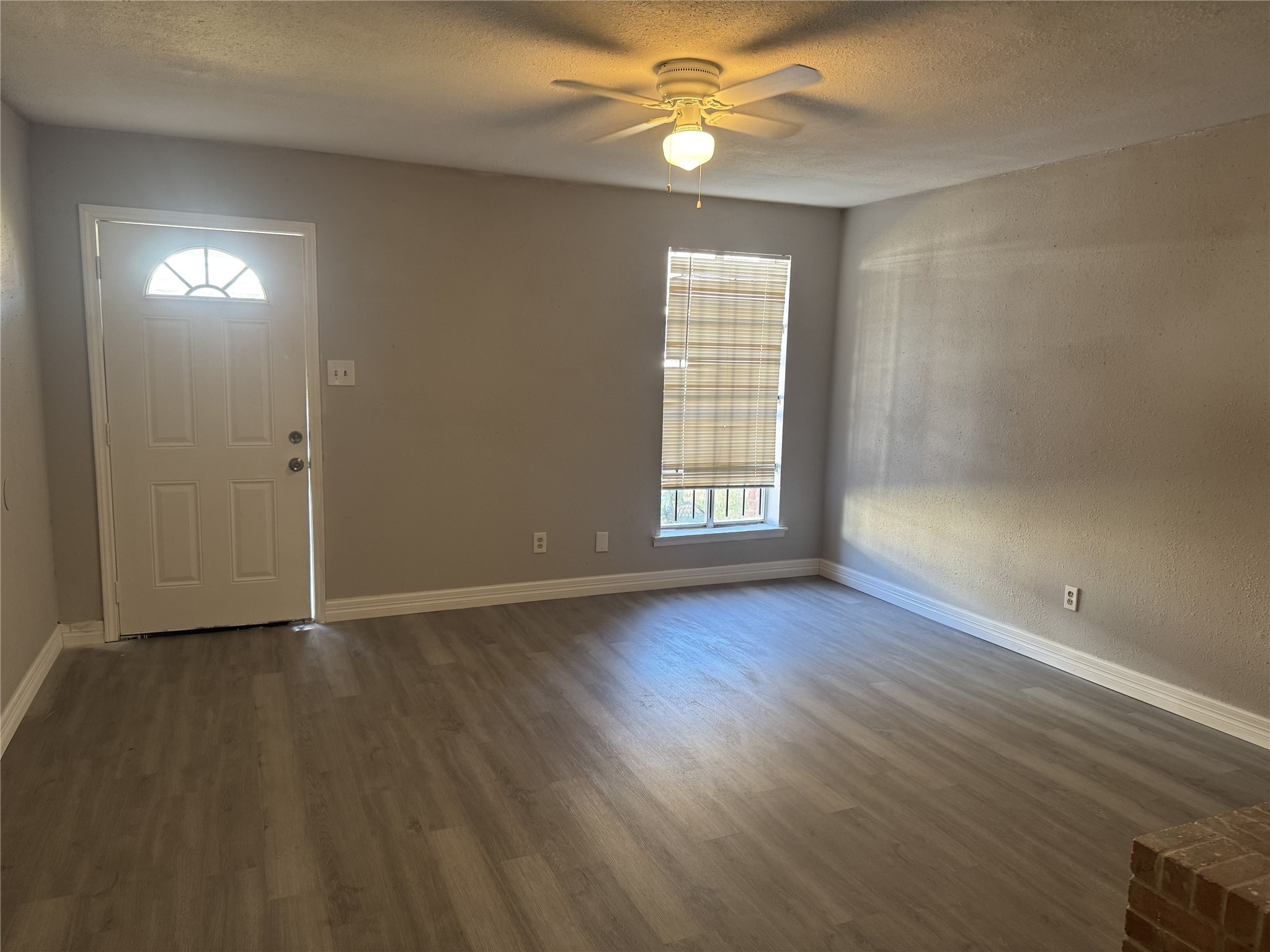9537 Braeburn Glen Boulevard Houston, TX 77074 - Photo 12 of 15 an empty room with wooden floor chandelier fan and windows