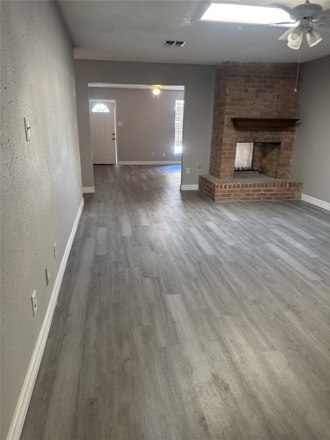 9537 Braeburn Glen Boulevard Houston, TX 77074 - Photo 10 of 15 an empty room with wooden floor and fireplace