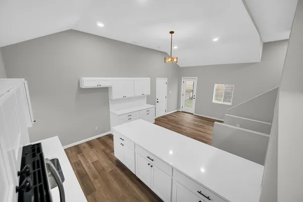 a kitchen with a stove and white cabinets