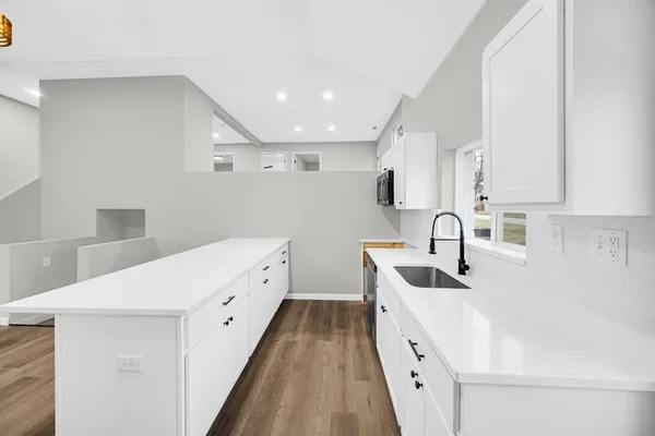 a large white kitchen with stainless steel appliances