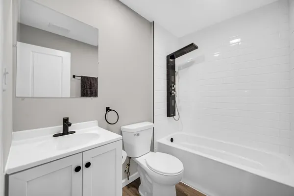 a bathroom with a granite countertop toilet sink and mirror