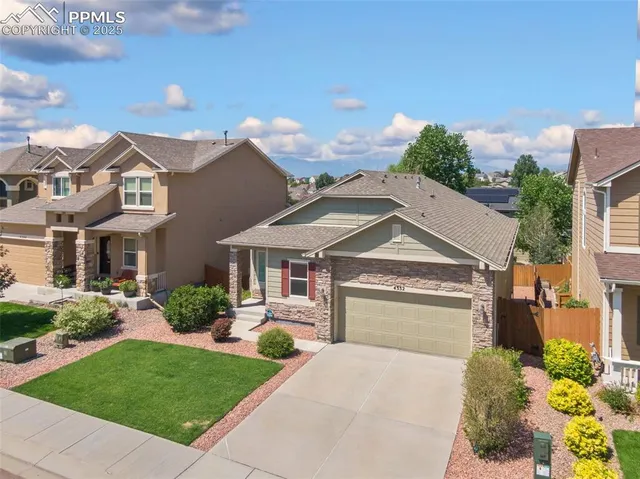 a front view of a house with a garden and plants