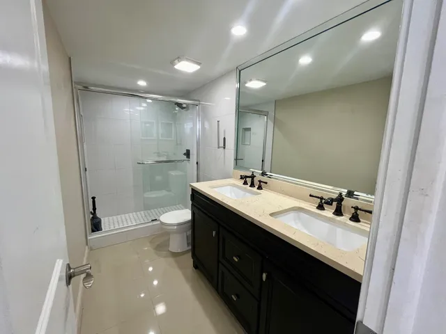 a bathroom with a double vanity sink mirror double shower and a bathtub