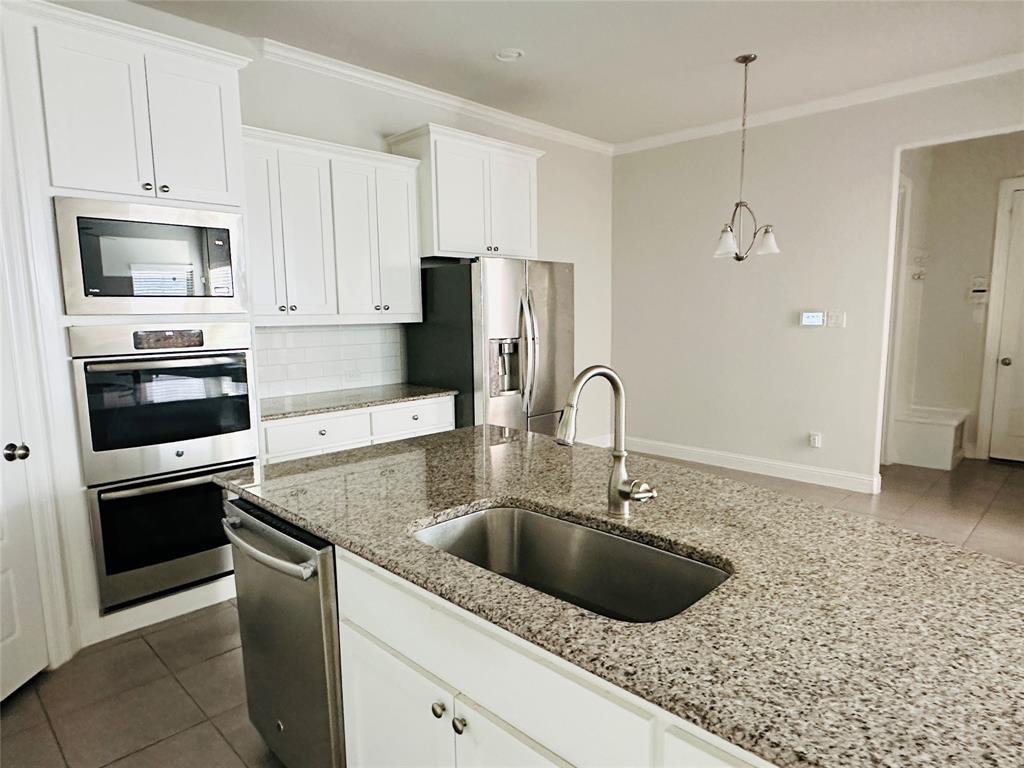 806 Davids Way Allen, TX 75013 - Photo 7 of 24 a kitchen with stainless steel appliances granite countertop a sink a stove a refrigerator and a microwave oven