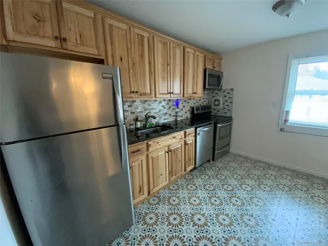 a kitchen with granite countertop a refrigerator and a sink