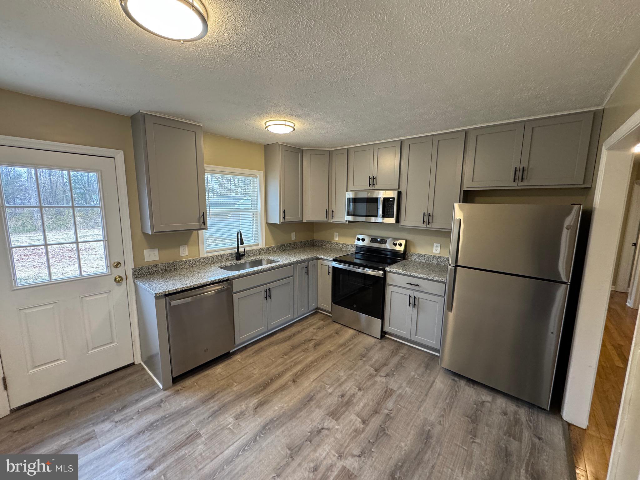 127 Longstreet Avenue Winchester, VA 22603 - Photo 5 of 18 a kitchen with granite countertop a refrigerator stove top oven and sink