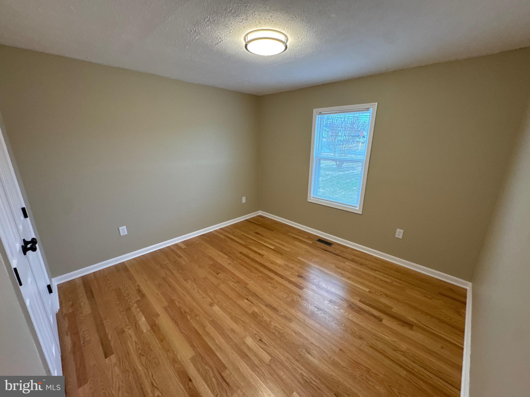 127 Longstreet Avenue Winchester, VA 22603 - Photo 9 of 18 an empty room with wooden floor and windows
