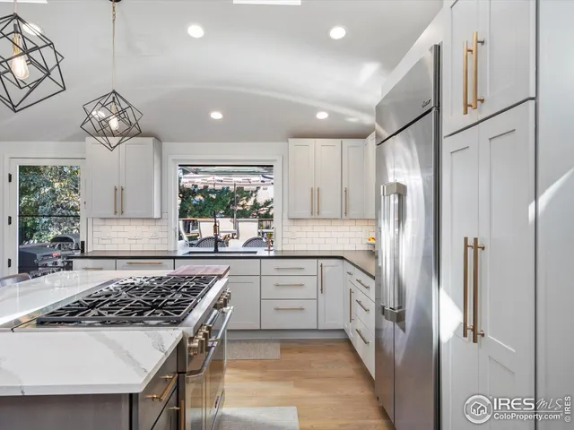 a kitchen with stainless steel appliances a stove a refrigerator and a sink