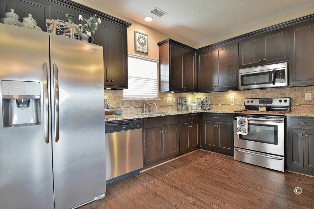 7 Eagle Ridge Lane Fort Mitchell, AL 36856 - Photo 8 of 24 a kitchen with stainless steel appliances granite countertop a refrigerator a stove and a sink with wooden floor