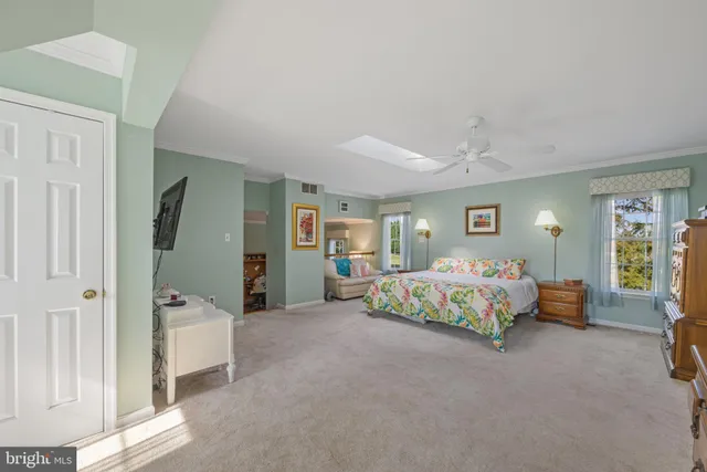 a living room with furniture large window and wooden floor