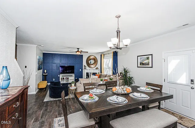 a view of a dining room with furniture a chandelier and wooden floor