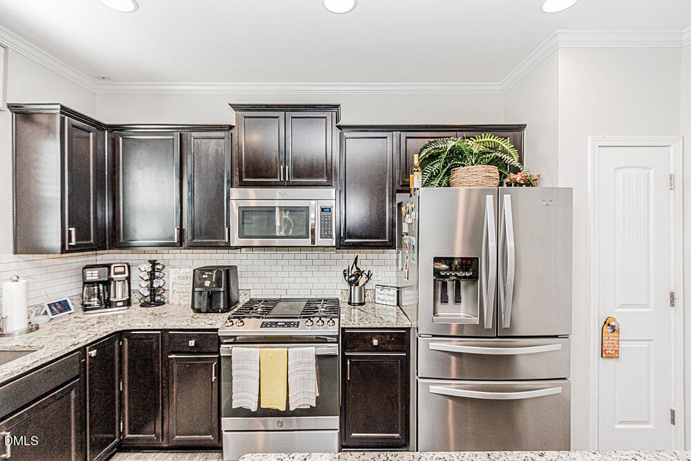 3425 Teravista Way Raleigh, NC 27616 - Photo 15 of 49 a kitchen with stainless steel appliances granite countertop a refrigerator and a stove