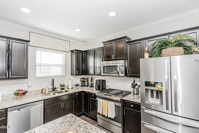 a kitchen with stainless steel appliances a refrigerator sink and stove