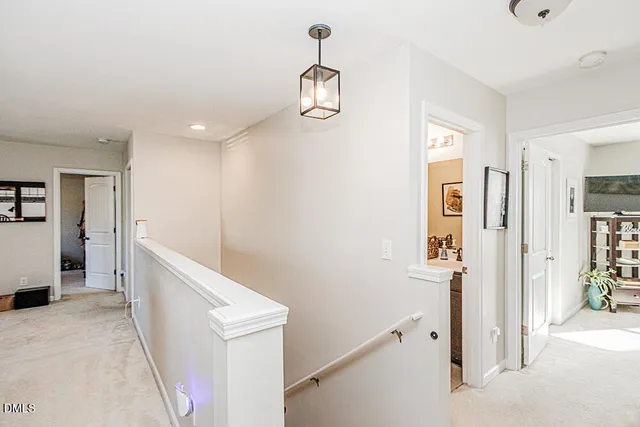 a hallway with white cabinets and chandelier