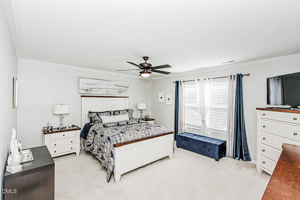3425 Teravista Way Raleigh, NC 27616 - Photo 28 of 49 a spacious bedroom with a bed and a chandelier