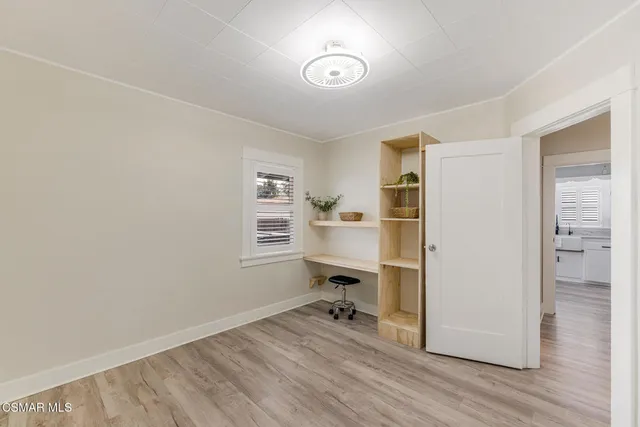 a view of a workspace with wooden floor and a window