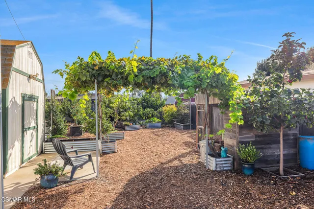 a backyard of a house with table chairs and a fire pit