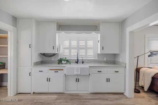 a kitchen with stainless steel appliances a sink window and cabinets