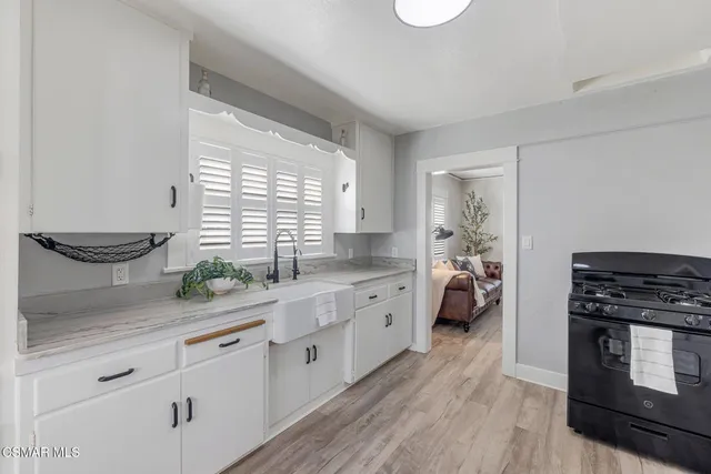 a kitchen with sink stove and cabinets