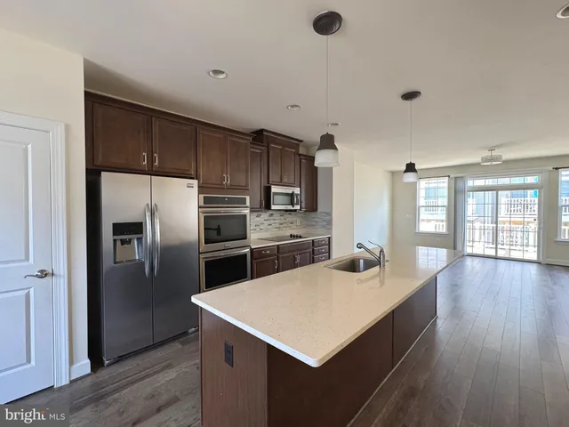 a kitchen with kitchen island a counter top space a sink and refrigerator