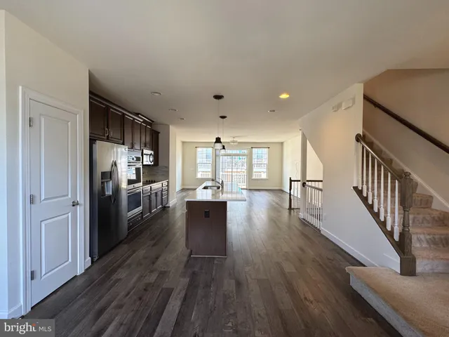 a view of a kitchen with wooden floor electronic appliances and furniture