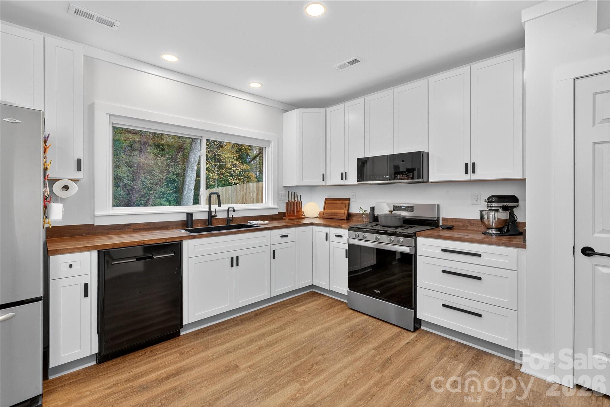 6431 Rosecrest Drive Charlotte, NC 28210 - Photo 29 of 46 a kitchen with granite countertop white cabinets and white appliances