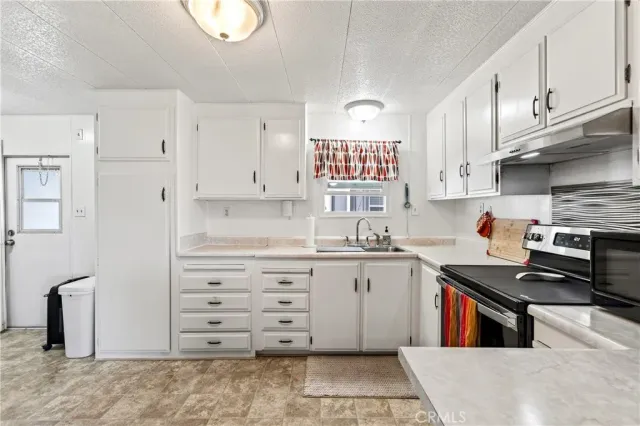 a kitchen with stainless steel appliances a stove a sink and a refrigerator