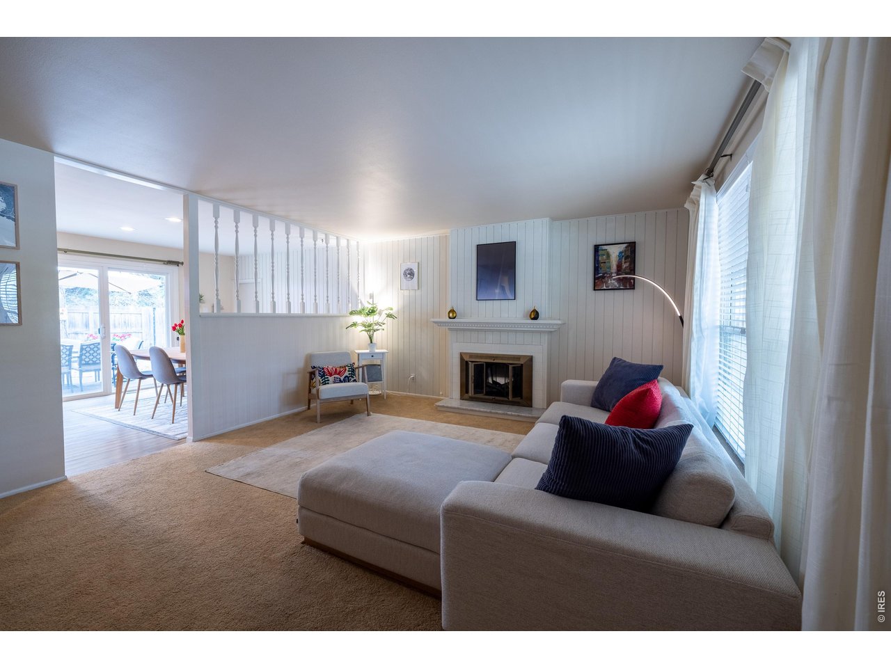 3320 23rd Street Boulder, CO 80304 - Photo 3 of 25 A bright, spacious gathering space with fireplace and easy flow into dining-ideal for everyday living and future updates. Existing hardwood flooring beneath the carpet offers great potential for easy upgrades.