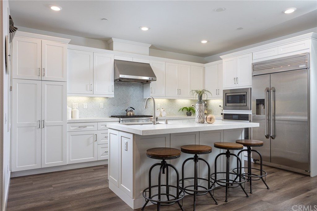 82 Ballast Point Tustin, CA 92782 - Photo 6 of 30 a kitchen with stainless steel appliances white cabinets and wooden floor