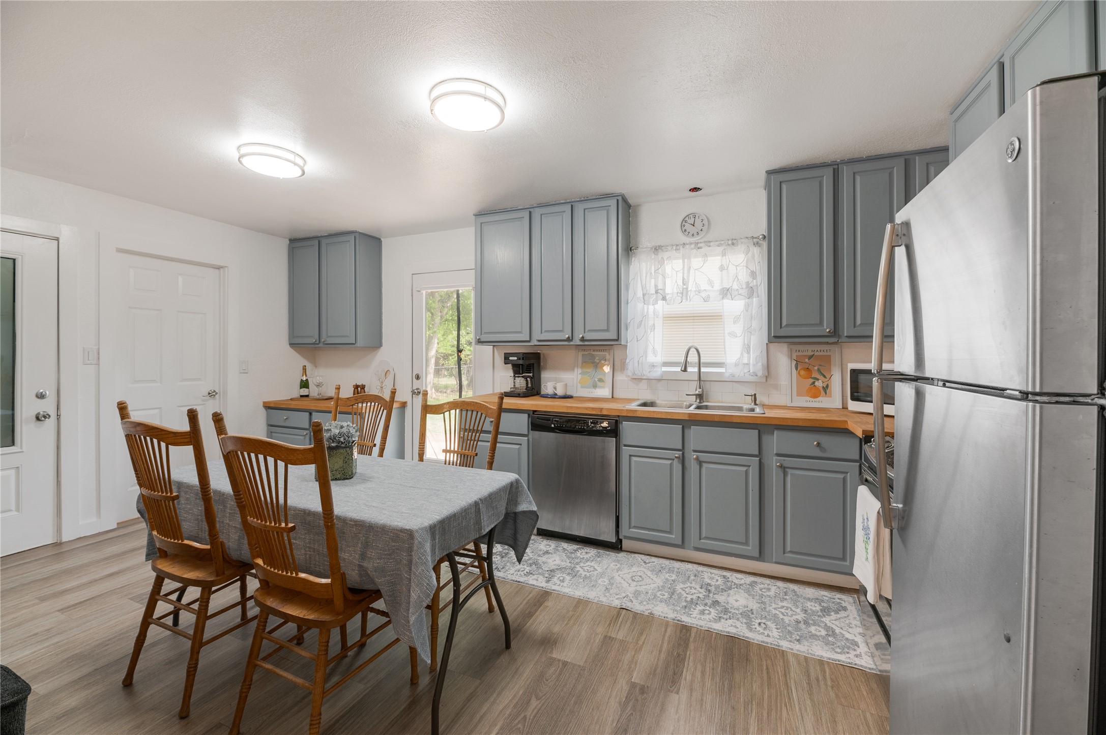 445 West Vaughan Street Bertram, TX 78605 - Photo 3 of 23 a kitchen with a table chairs refrigerator and microwave